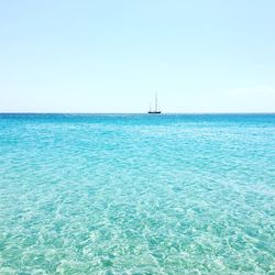 View of sailboat in sea against clear sky