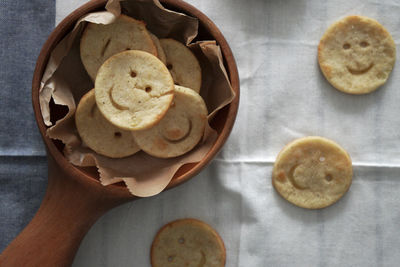 There are some lovely and delicious smiley face potato cakes in the wooden bowl