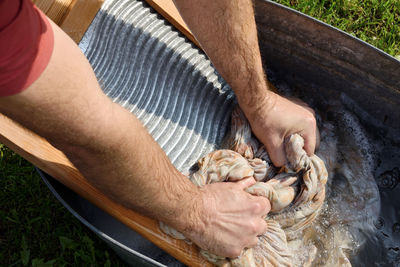  man washing clothes with a washboard 