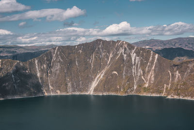 Scenic view of lake by mountains against sky