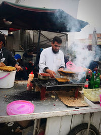 Man preparing food at market stall