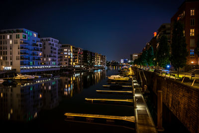 Illuminated cityscape against clear sky at night
