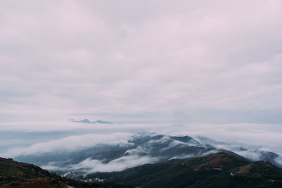 Scenic view of mountains against cloudy sky