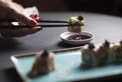 Close-up of hand holding tea cup on table