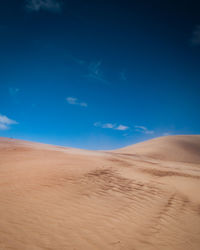 Scenic view of desert against blue sky
