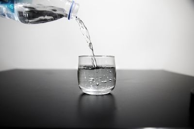 Close-up of wineglass on glass of table