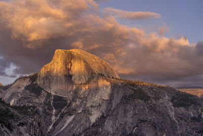 Rock on landscape against sky during sunset