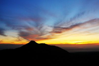 Scenic view of silhouette mountains against sky at sunset