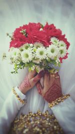 Close-up of woman holding red flowers