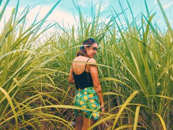 Side view of young woman standing on field