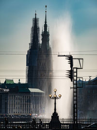 Alster lake by historic buildings against sky