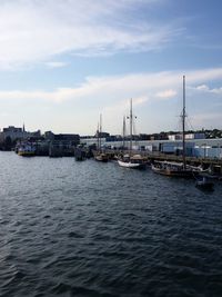 View of marina at harbor against cloudy sky