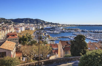 Residential district by harbor against clear sky