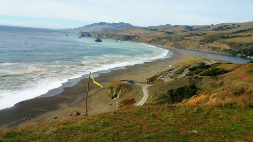 Cliffs edge. aerial. wind flags. ocean curve with white frothy waves. background.