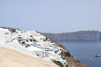 Aerial view of town by sea against clear sky