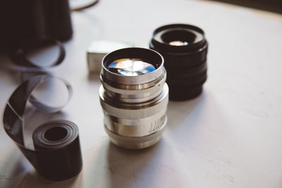 Vintage camera, film, retro lenses on white table,