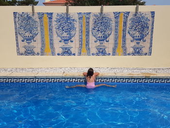 Rear view of young woman in swimming pool