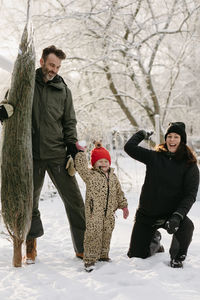 Happy mother and daughter throwing snowballs