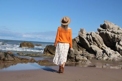 Rear view of woman walking at beach