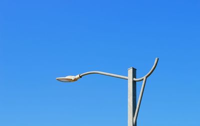 Low angle view of windmill against clear blue sky