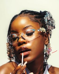 Portrait of young woman with eyes closed against white background