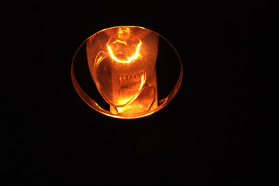 Close-up of illuminated lamp against black background