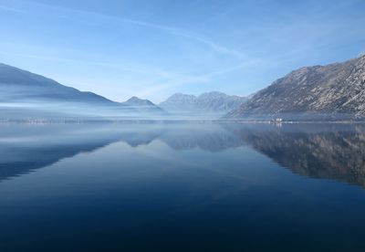 Scenic view of lake and mountains against blue sky