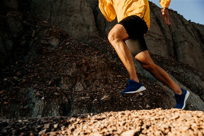 Low section of man running on land