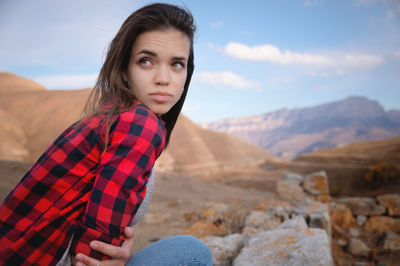 Portrait of attractive caucasian young woman enjoying in the mountains against the background