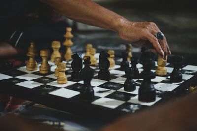 Cropped hand of woman playing chess