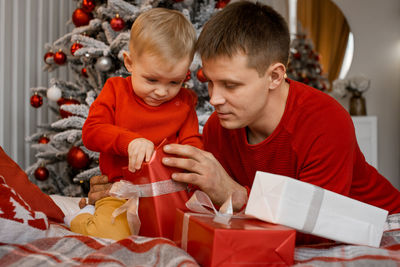 A father and young son opening christmas presents