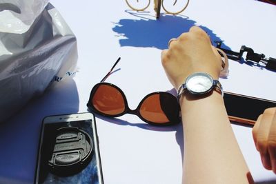 Close-up of hand holding eyeglasses on table