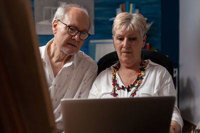 Portrait of smiling woman using laptop at home