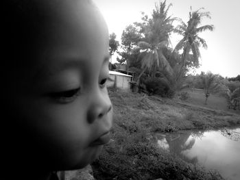 Portrait of boy looking away against trees