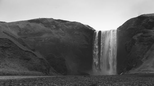 Scenic view of waterfall against sky