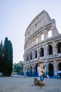 Rear view of woman on historical building against sky