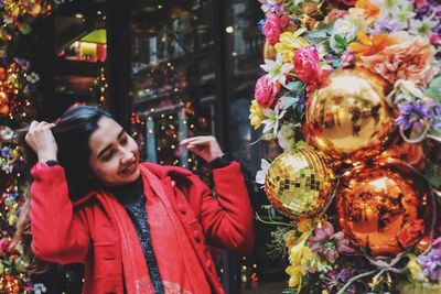 Young woman smiling while looking at christmas decorations outdoors