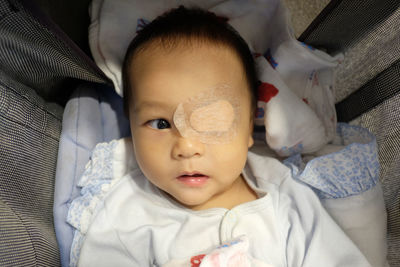 High angle view of cute baby boy with bandage on eye