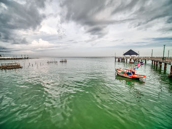 Fishing boat in sea against sky