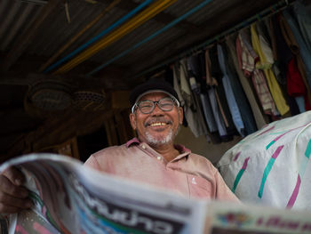 Portrait of smiling man with sheet in store