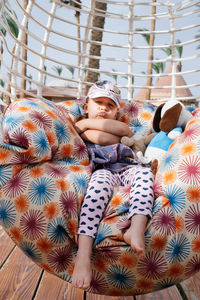 Serious toddler girl on the swing. stylish and moody child having rest. summer rest. conflicts