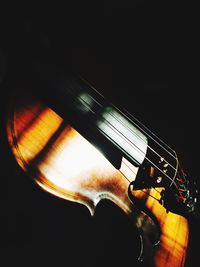 Close-up of man playing guitar against black background