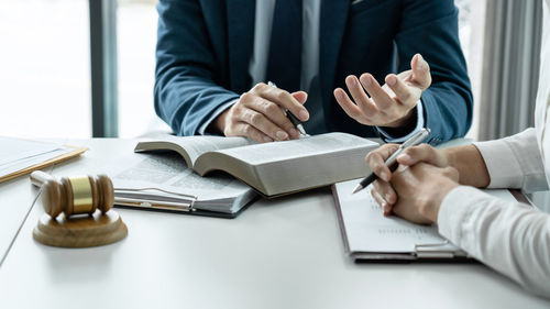 Midsection of business colleagues working on table