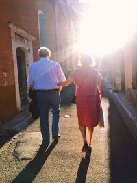 Rear view of friends walking on street in city