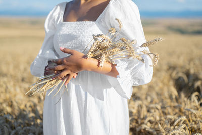 Midsection of woman standing in field