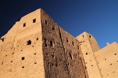 Low angle view of built structure against clear blue sky