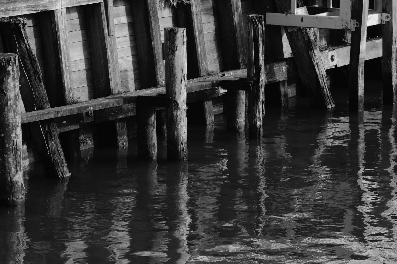 FULL FRAME SHOT OF OLD PIER OVER RIVER AGAINST BUILDINGS