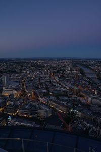 High angle view of illuminated buildings in city against clear sky