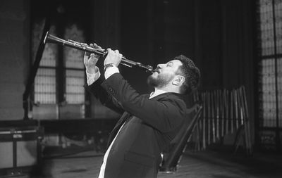 Man playing clarinet while standing at studio