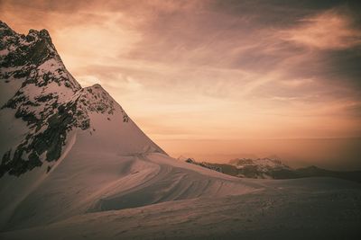 Scenic view of snowcapped mountain against sky during sunset